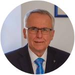 Ein Mann mit Brille und kurzen, grauen Haaren blickt in die Kamera