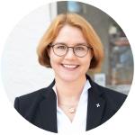 eine Frau im weißen Hemd mit schwarzem Jacket
