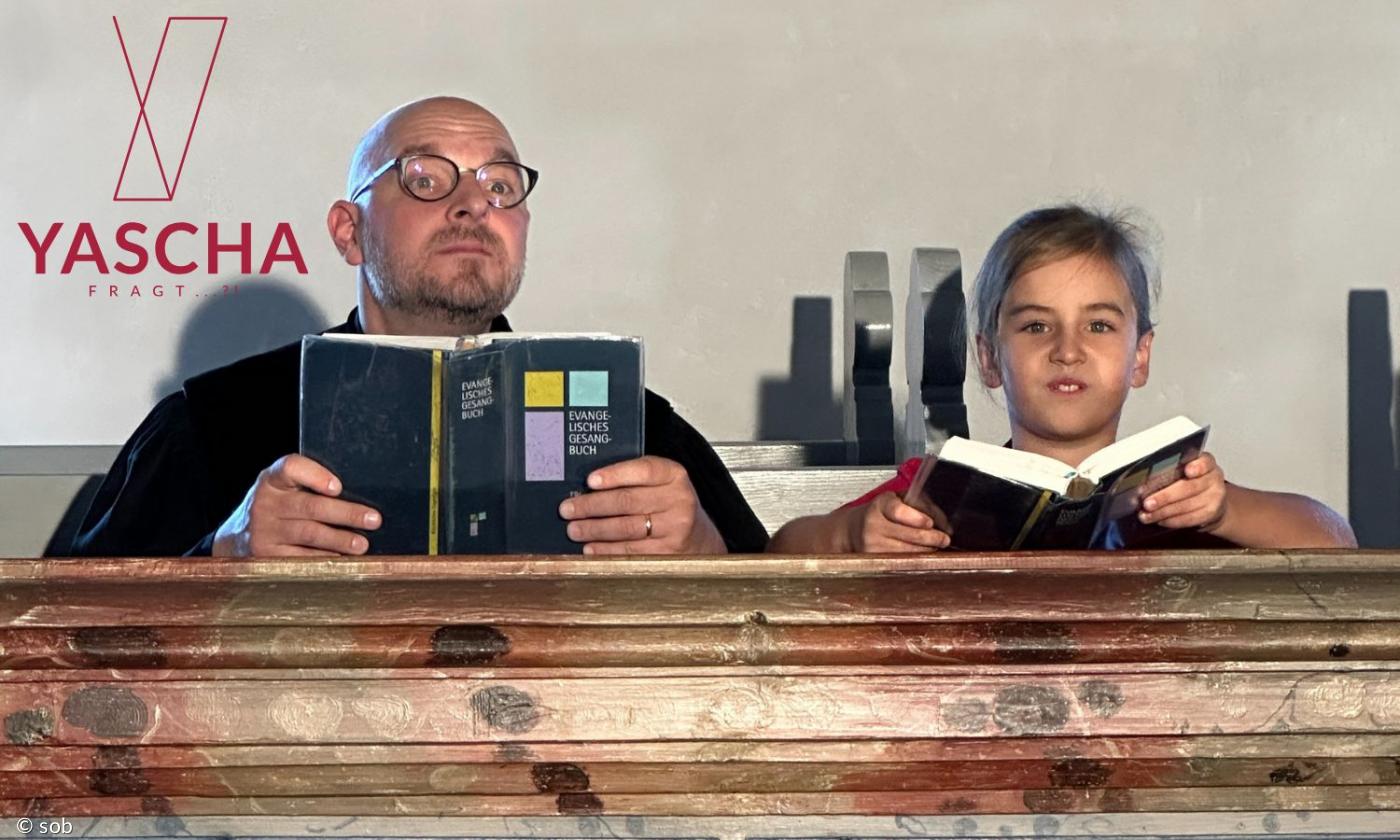 Ein Pfarrer und ein Junge sitzen auf einer Kirchenbank