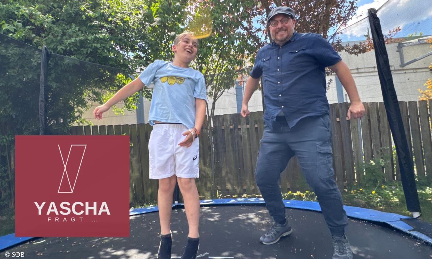 Ein Junge und ein Mann auf einem Trampolin, sie hüpfen
