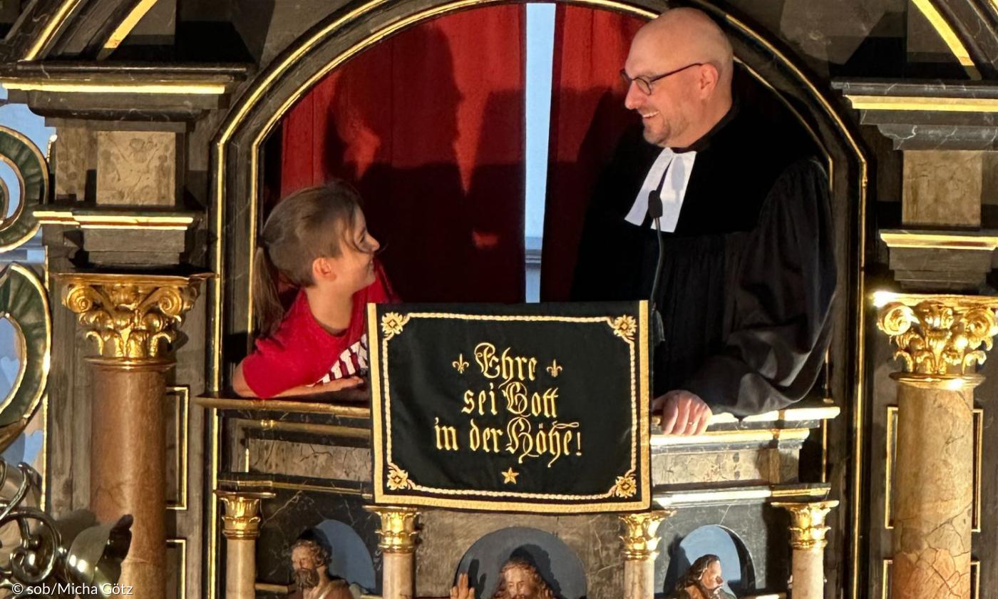 Ein junge und ein Pfarrer auf der Kanzel