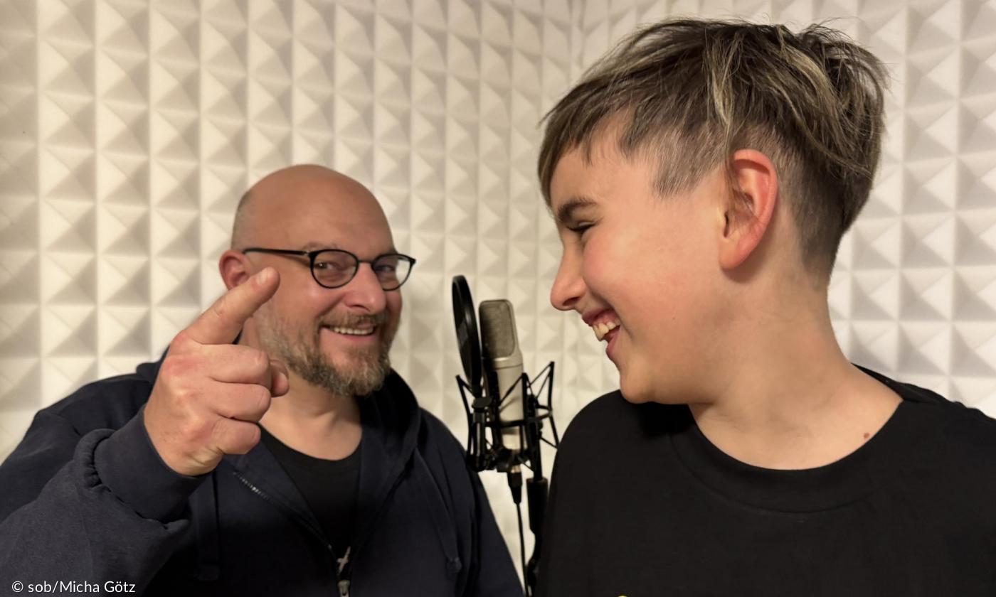 Ein Mann und ein Junge am Mikrofon