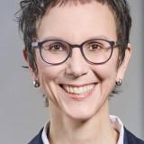 Eine Frau mit Brille, sie lächelt