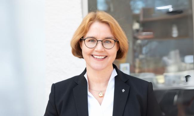 eine Frau im weißen Hemd mit schwarzem Jacket