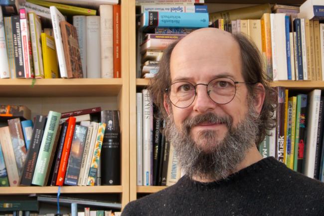 Ein Mann vor einem Bücherregal