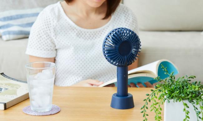 Eine Frau sitzt vor einem Ventilator