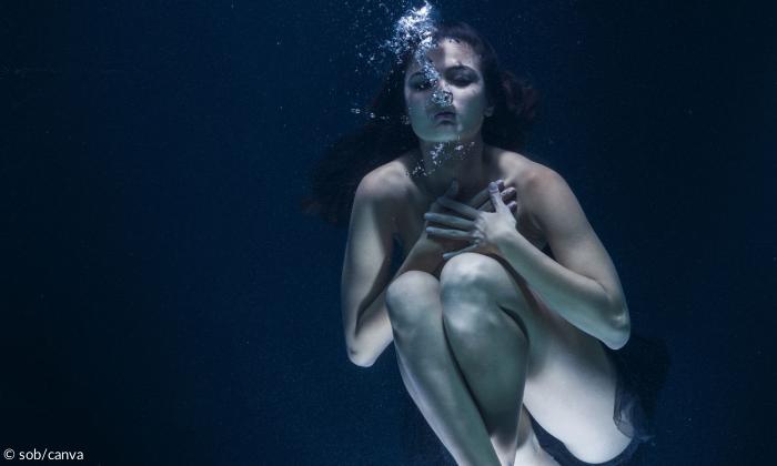 Frau taucht im Becken
