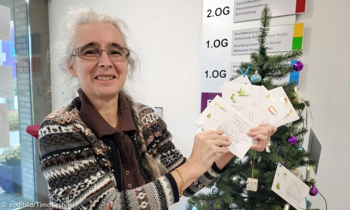 Ulla Langer von der Kirchlichen Allgemeinen Sozialarbeit (KASA) der Diakonie beim Schmücken eines "Wuschbaums"