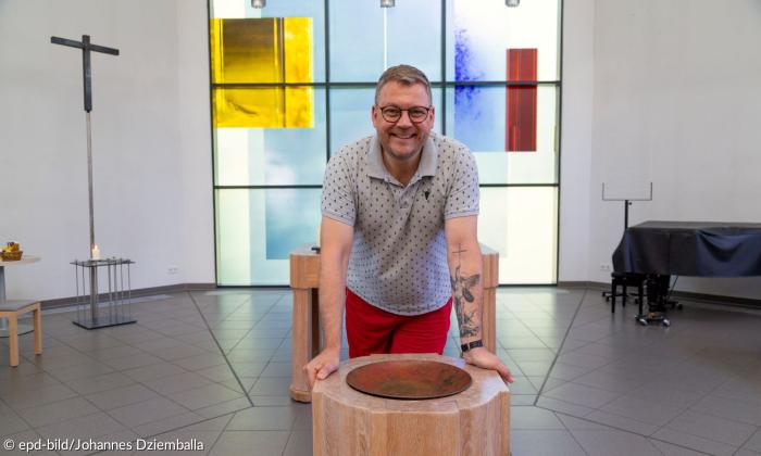 Ein Mann mit Tattoo in einer Kirche