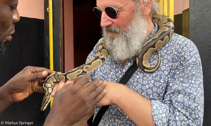Bärtiger Tourist mit Python aus dem wichtigsten Voodoo-Tempel Ouidahs