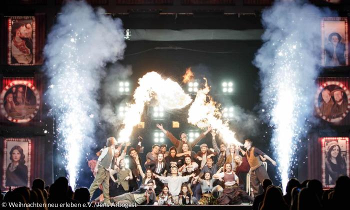 Menschen auf einer großen Bühne, mit Pyroeffekten