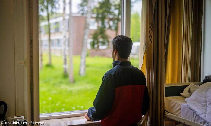 Ein Mann schaut aus dem Fenster