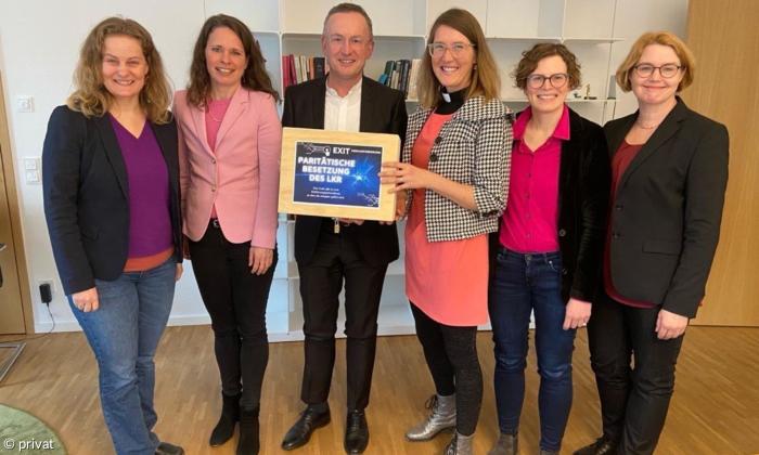 Fünf Frauen und ein Mann stehen in einer Reihe