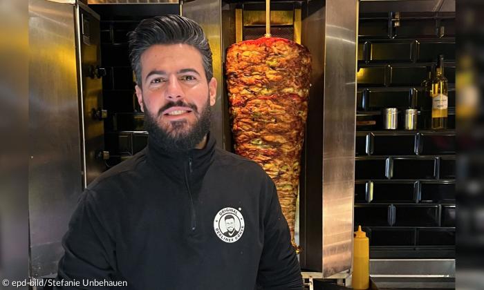 Ein Mann vor einem Dönerspieß