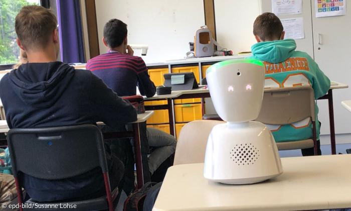 Schüler sitzen in der Schule und ein Roboter hilft. 