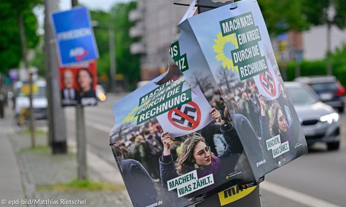 Wahlplakate der Grünen mit durchgestrichenem Hakenkreuz, dahinter Plakate von AfD und SPD