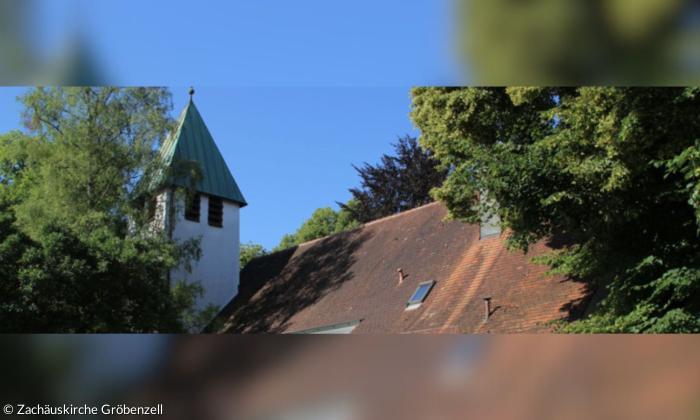 Ein Kirchendach und ein Glockenturm