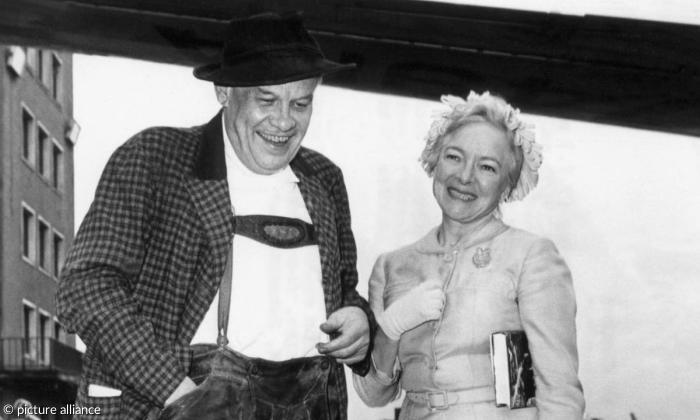 Oskar Maria Graf und die Schauspielerin Helen Hayes posieren am 3. Juli 1958 nach ihrer Landung auf dem Flughafen München-Riem für die Fotografen.