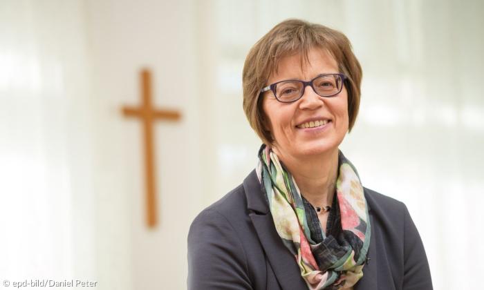 Eine Frau vor einem Kreuz