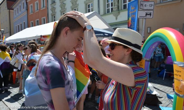 Eine Frau legt die Hände auf den Kopf einer anderen Person
