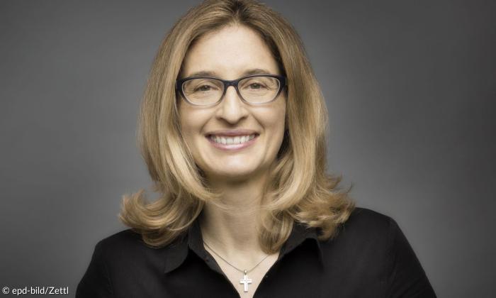 Eine Frau mit Brille, sie lächelt