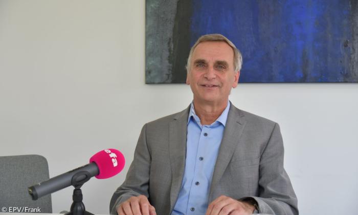 Ein Mann im grauen Sakko und hellblauem Hemd