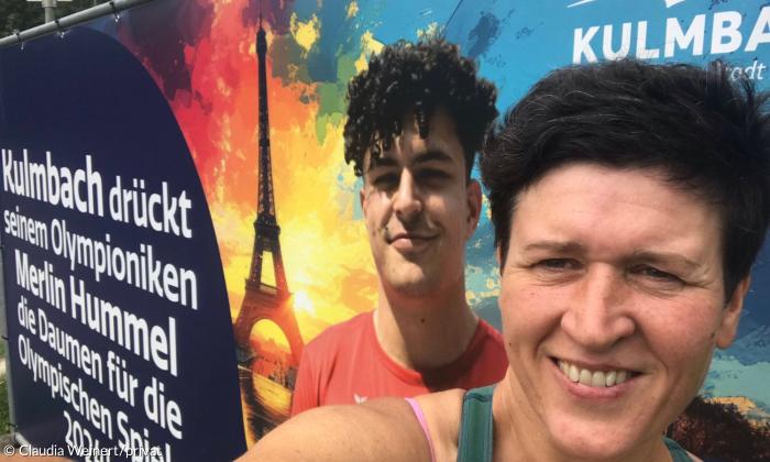 Eine Frau steht vor einem Plakat, das einen jungen Mann zeigt
