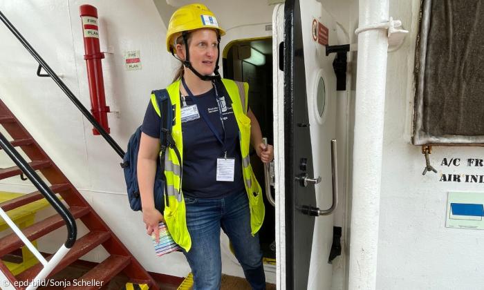 Inga Thom, Mitarbeiterin der Seemannsmission Cuxhaven, kommt aus dem Schiffsinneren an Deck der BBC Coral
