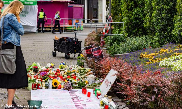 Eine Frau steht vor Kerzen und Blumen
