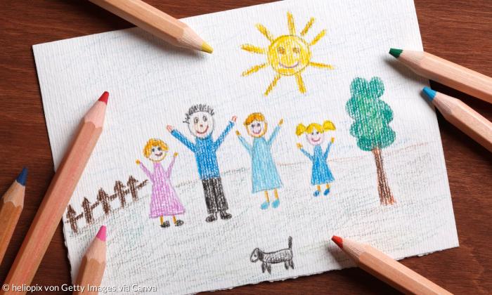 Ein gezeichnetes Bild von einer Familie mit Buntstiften neben dem Papier