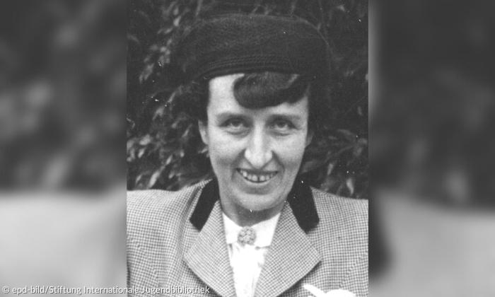 Schwarz-weiß-Bild einer Frau mit Mütze, sie lächelt