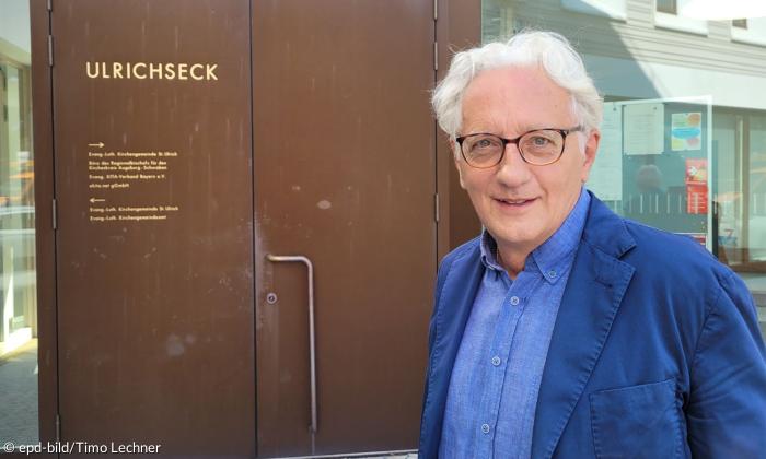 Äterer Mann mit Brille vor Tür der Kirchengemeinde Ulrichseck