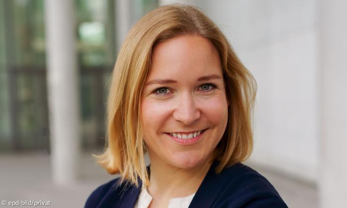 Eine Frau mit schulterlangen Haaren, sie lächelt