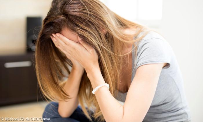 Eine Frau verbirgt die Hände im Gesicht