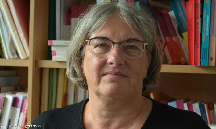 Eine Frau mit kurzen grauen Haaren und Brille