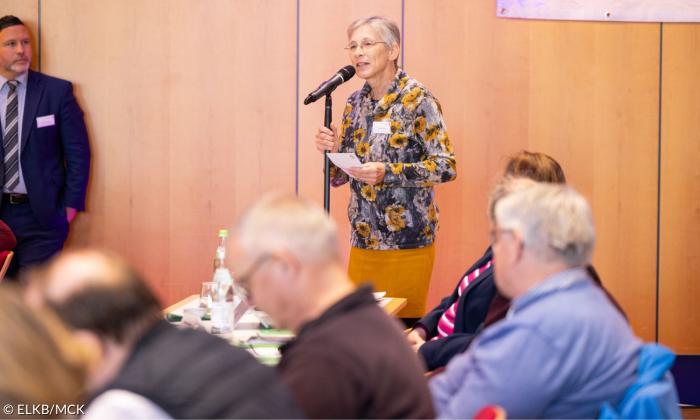 Eie Frau spricht in ein Mikrofon