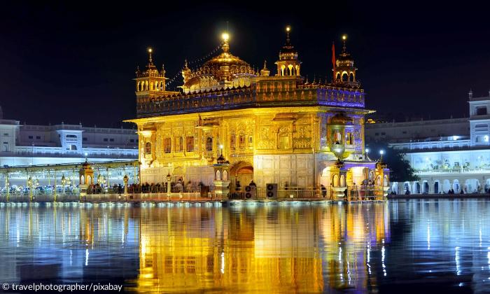 Ein goldener Tempel welcher in der Nacht beleuchtet wird