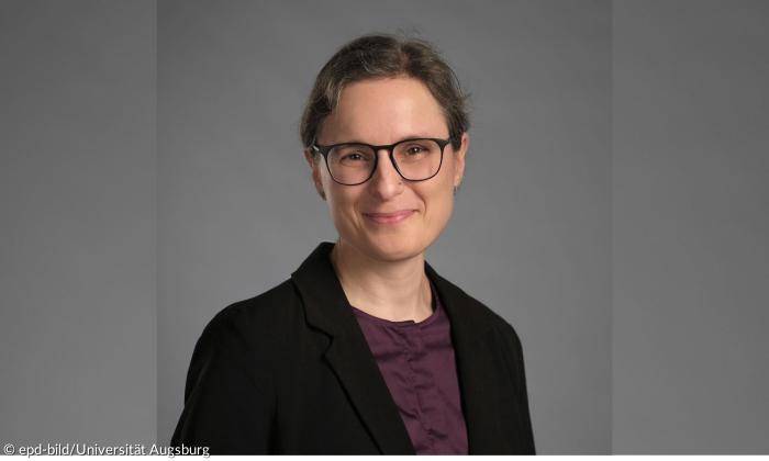 Eine Frau mit Brille, sie lächelt