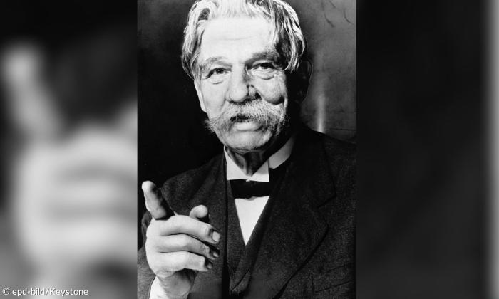 Ein Mann mit buschigem Schnauzbart in schwarz-weiß