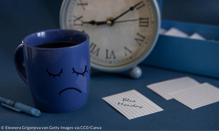 Eine blaue Tasse neben einem Zettel, auf dem blue monday steht