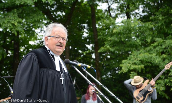 Ein Mann im Talar mit Kreuz um den Hals