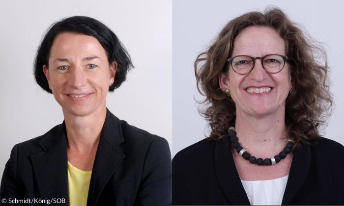 Zwei Frauen mit schwarzem Blazer lächeln in die Kamera