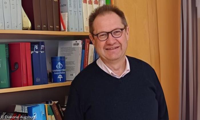 Ein Mann steht vor einem Bücherregal