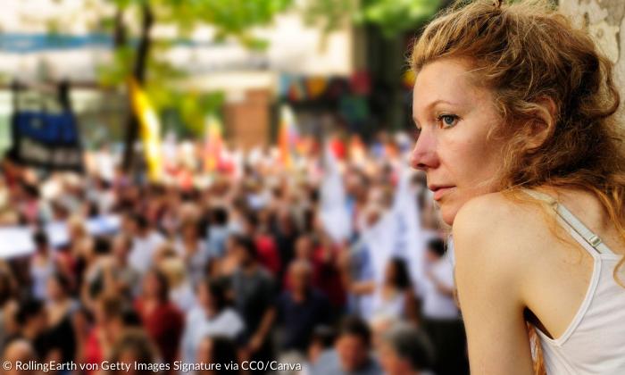 Eine Frau blickt in Richtung einer Demonstration
