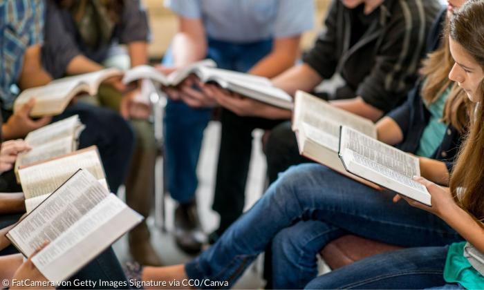 Junge Menschen lesen in aufgeschlagenen Bibeln