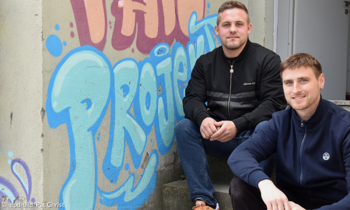Junge Männer vor Graffitiwand Fansozialarbeiter Jonathan Freudenberger und  Johannes Bork