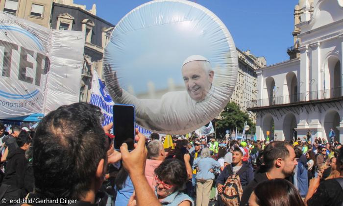 In Argentinien fotografiert ein Mann mit seinem Smartphone einen Ballon mit Foto von Papst Franziskus