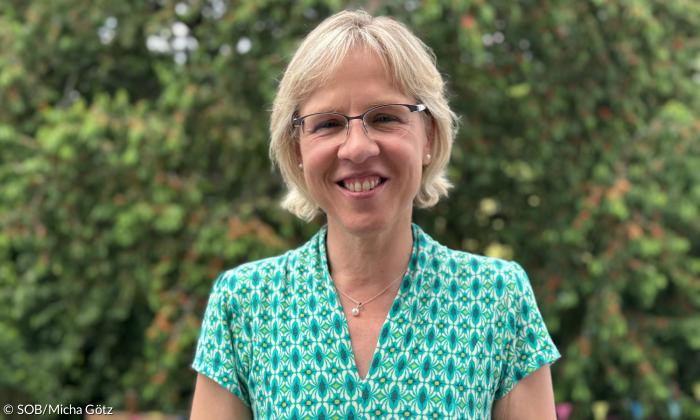 Eine Frau mit Brille, sie lächelt