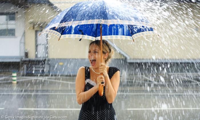Eine Frau im Regen mit Regenschirm