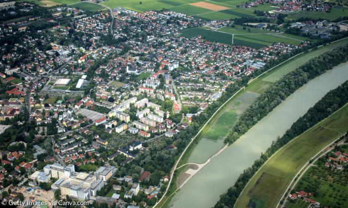 Eine Luftaufnahme mit Fluss, Wiesen und Häusern